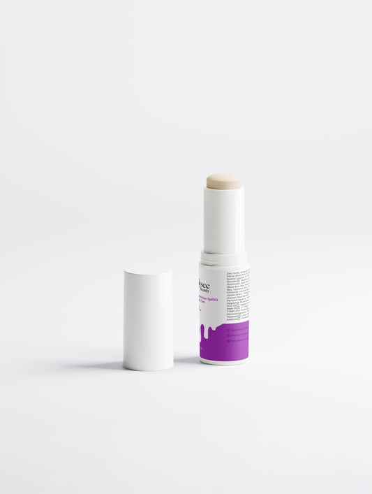 A visual arrangement of sunflower seeds, rice husks, and jojoba oil droplets surrounding the SPF 50 stick, emphasizing its hydrating and vegan ingredients.