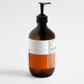 Brown bottle with pump and orange label on a white background