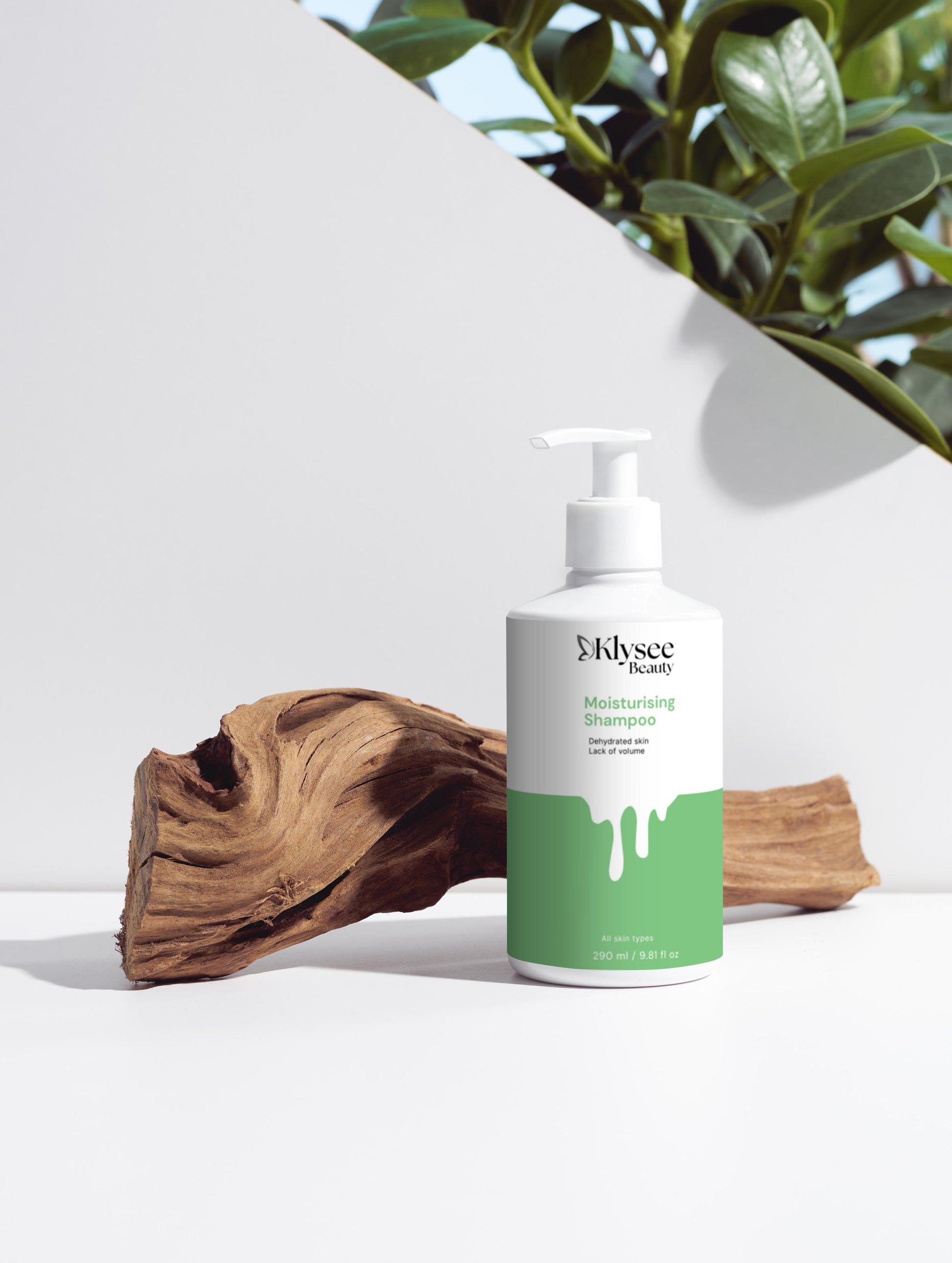 Klysee shampoo bottle with green label on a white surface with natural elements