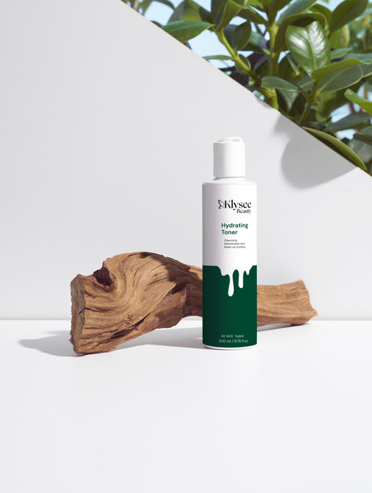 Skincare bottle with green and white design on a white surface with natural elements.