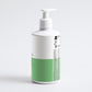 White and green bottle with pump on a light gray background