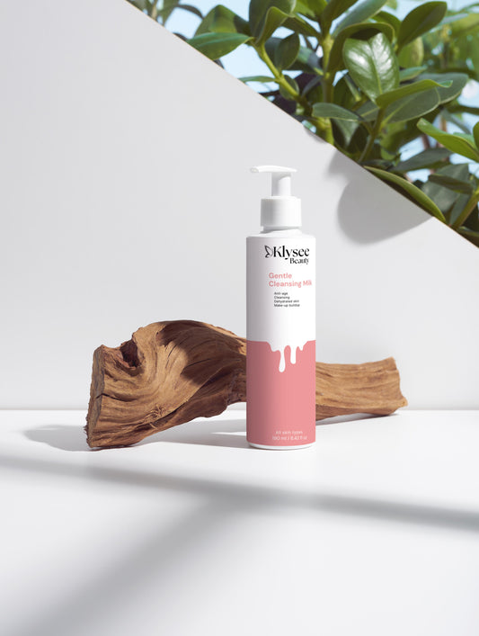 Skincare bottle with pink and white design on a light surface with a plant in the background